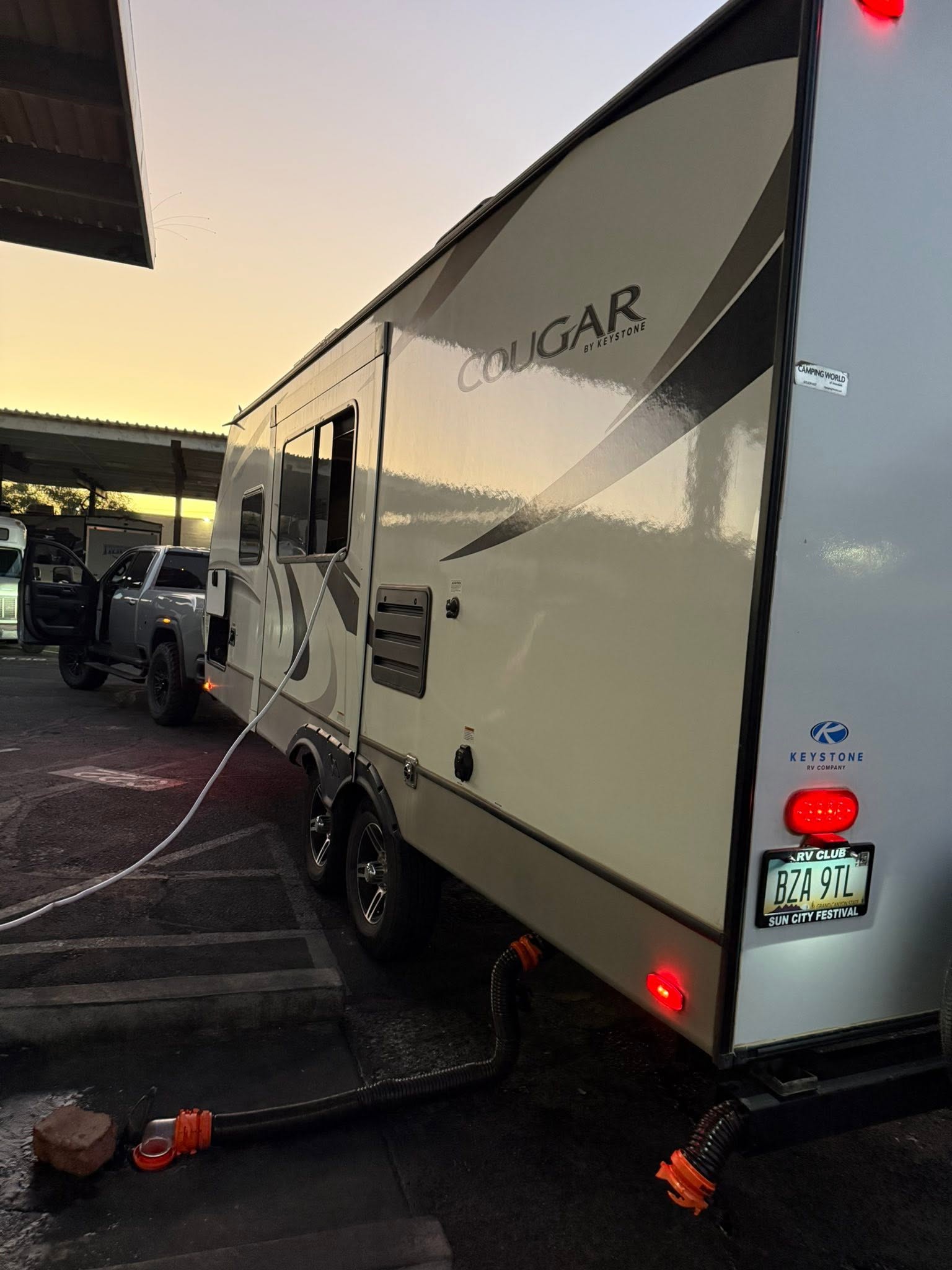 Keystone Cougar exterior from the rear corner, hooked up at its parking spot