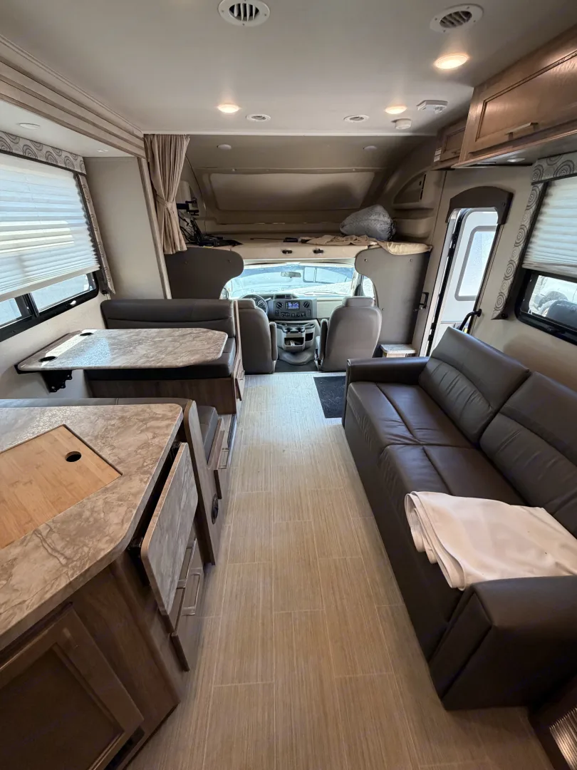 Entegra Coach Odyssey interior looking forward toward the cab over the sofa and dinette